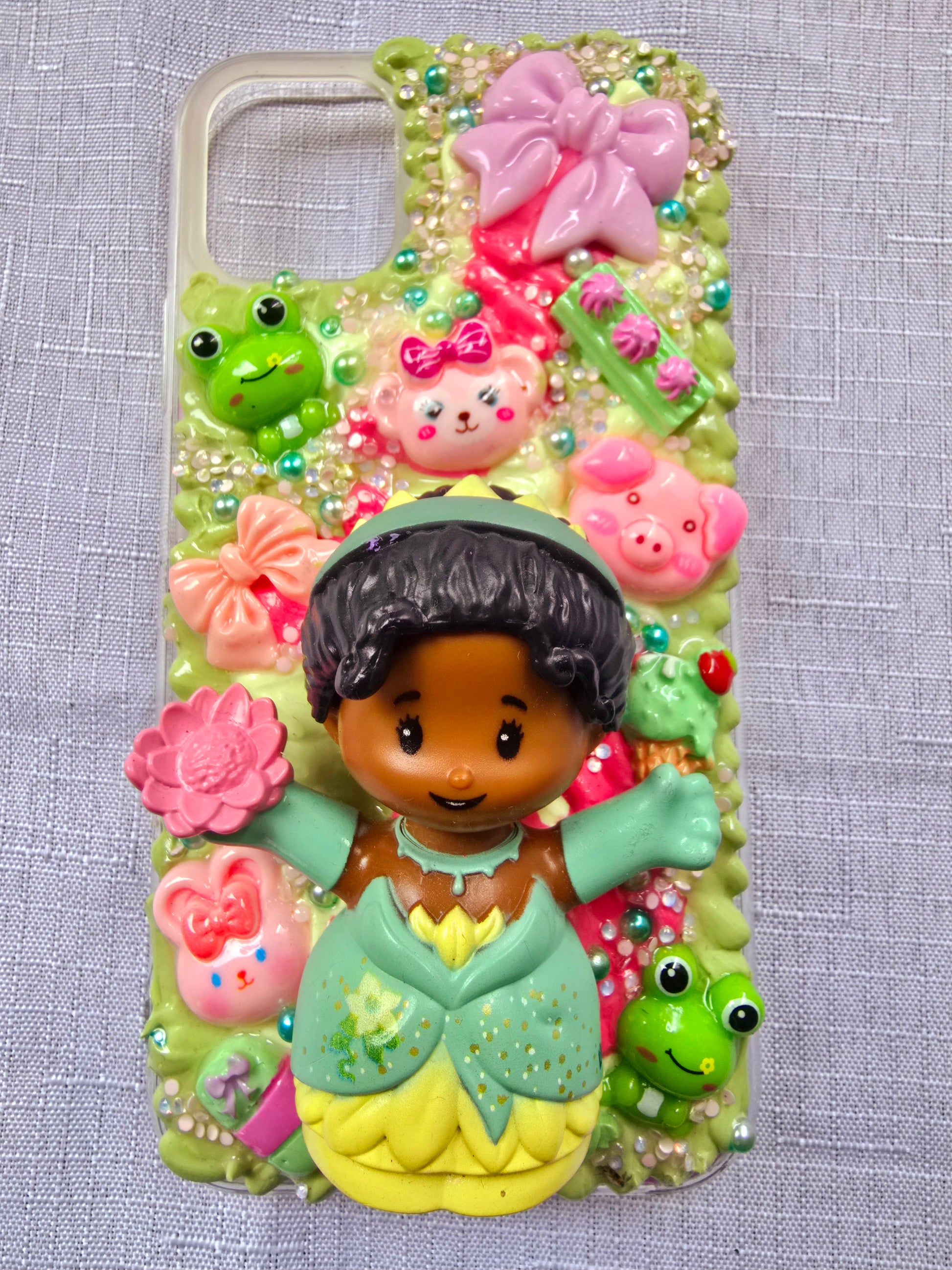 Handmade iPhone 11 phone case in green and pink, featuring a princess theme with floral, animal, and bow accents – cute and whimsical design.