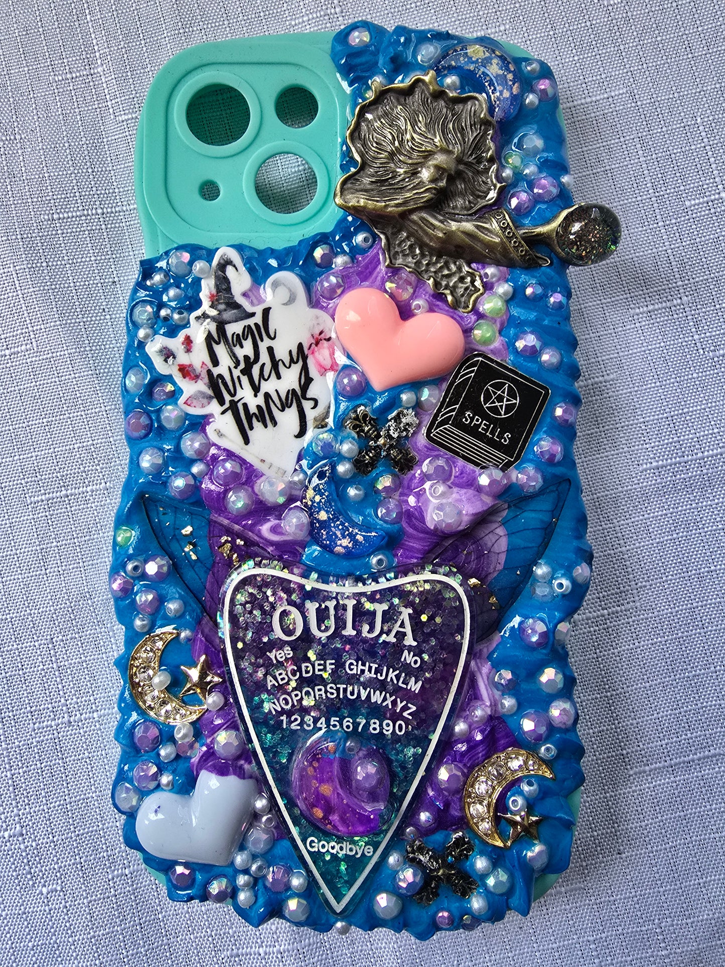 Handmade iPhone 13 phone case in blue and purple with a spiritual and witchy aesthetic, featuring mystical and magical-themed decorations.